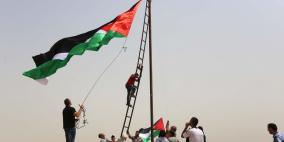 فلسطينيون يرفعون العلم الفلسطيني خلال تظاهرة ضد الاستيطان في قرية النبي صالح