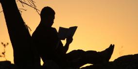 رجل يقرأ القرآن أثناء غروب الشمس  في مدينة رام الله