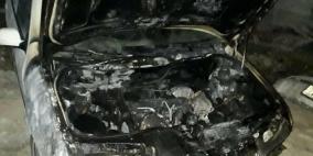 مستوطنون يحرقون مركبة ويخطون شعارات عنصرية