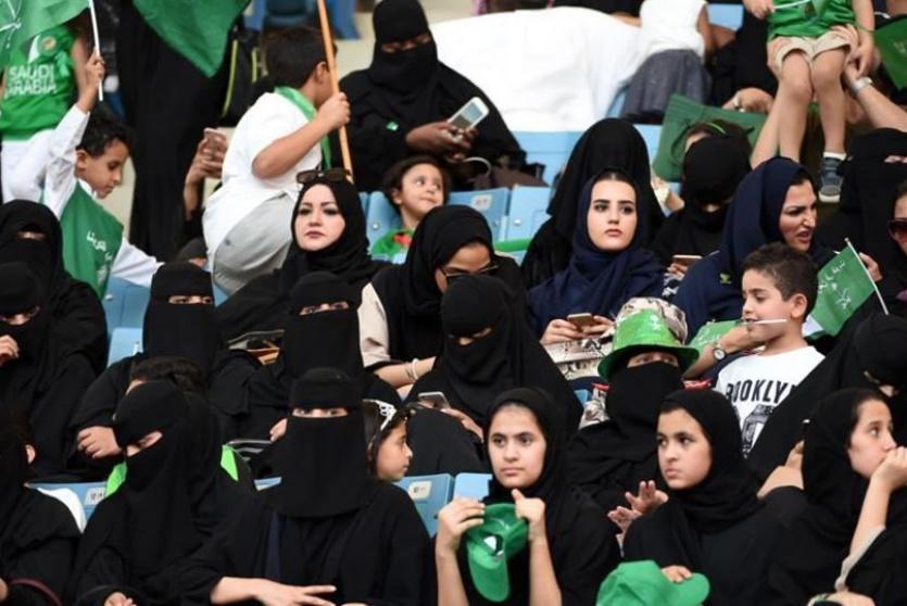 نساء يشاهدن مباراة في ملعب كرة قدم