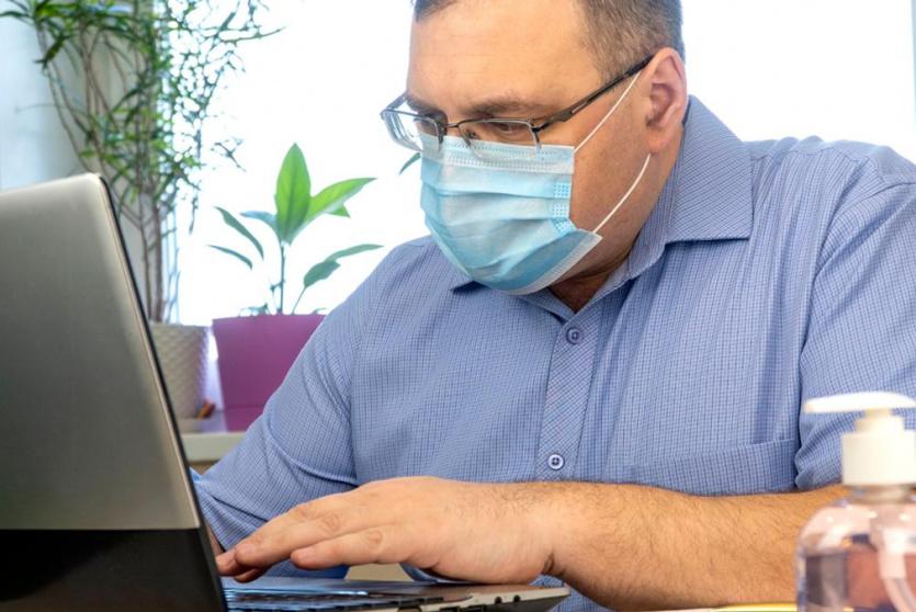 موظف يرتدي كمامة اثناء عمله 