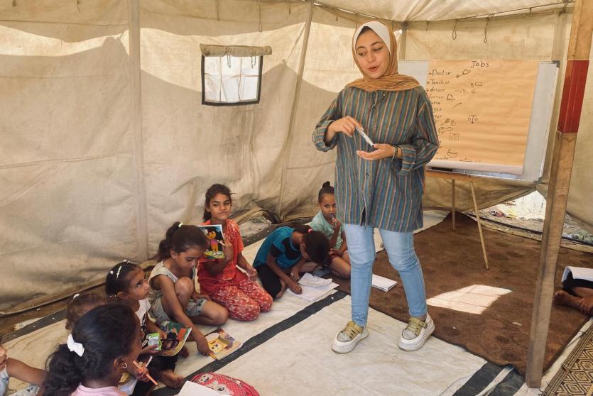 أطفال يتلقون حصة دراسية داخل خيمة في غزة