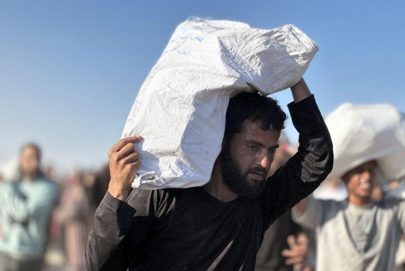مواطن يحمل بعض الطعام حصل عليه جنوب قطاع غزة