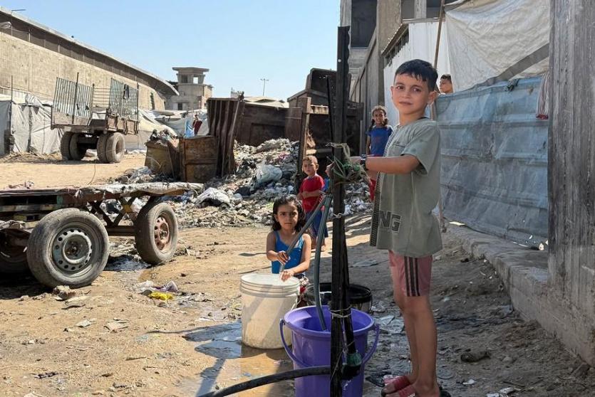 أطفال يحاولون الحصول على المياه من مضخة في مدينة غزة