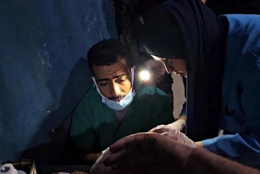 طبيب يجري عملية جراحية على ضوء بدائي جراء انقطاع الكهرباء 