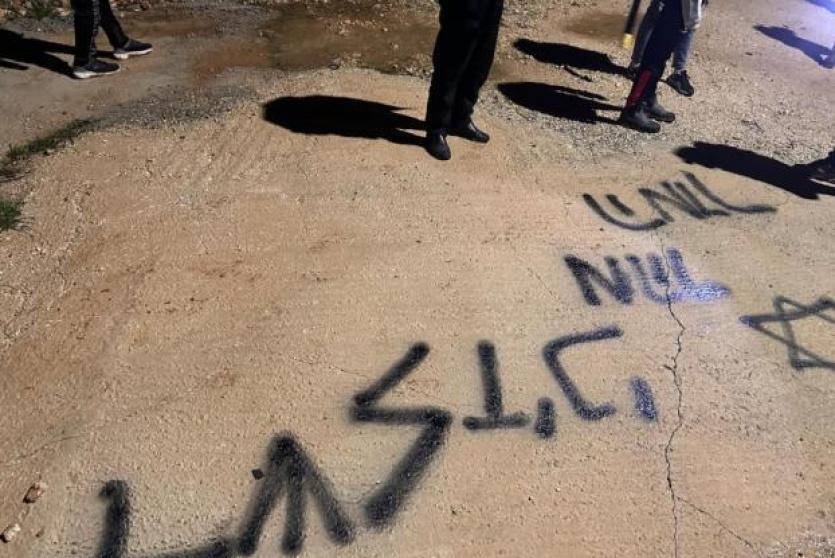 مستوطنون يحرقون مركبة ويخطون شعارات عنصرية في بلدة عطارة